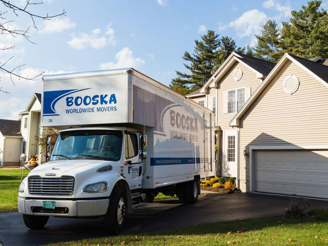 Booska Moving truck parked in the driveway of a home, representing the final stage of the home sale and preparing for moving day.