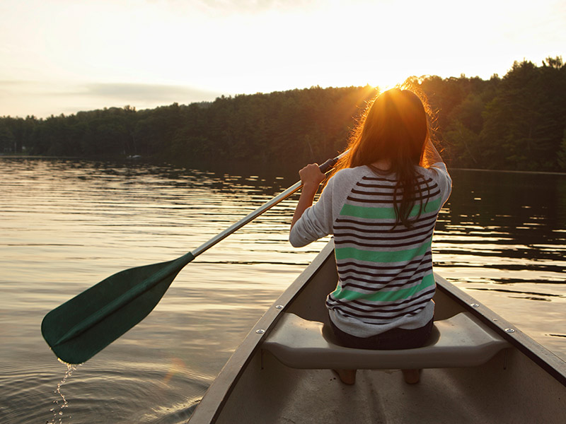 A woman kayaking a small lake in Vermont